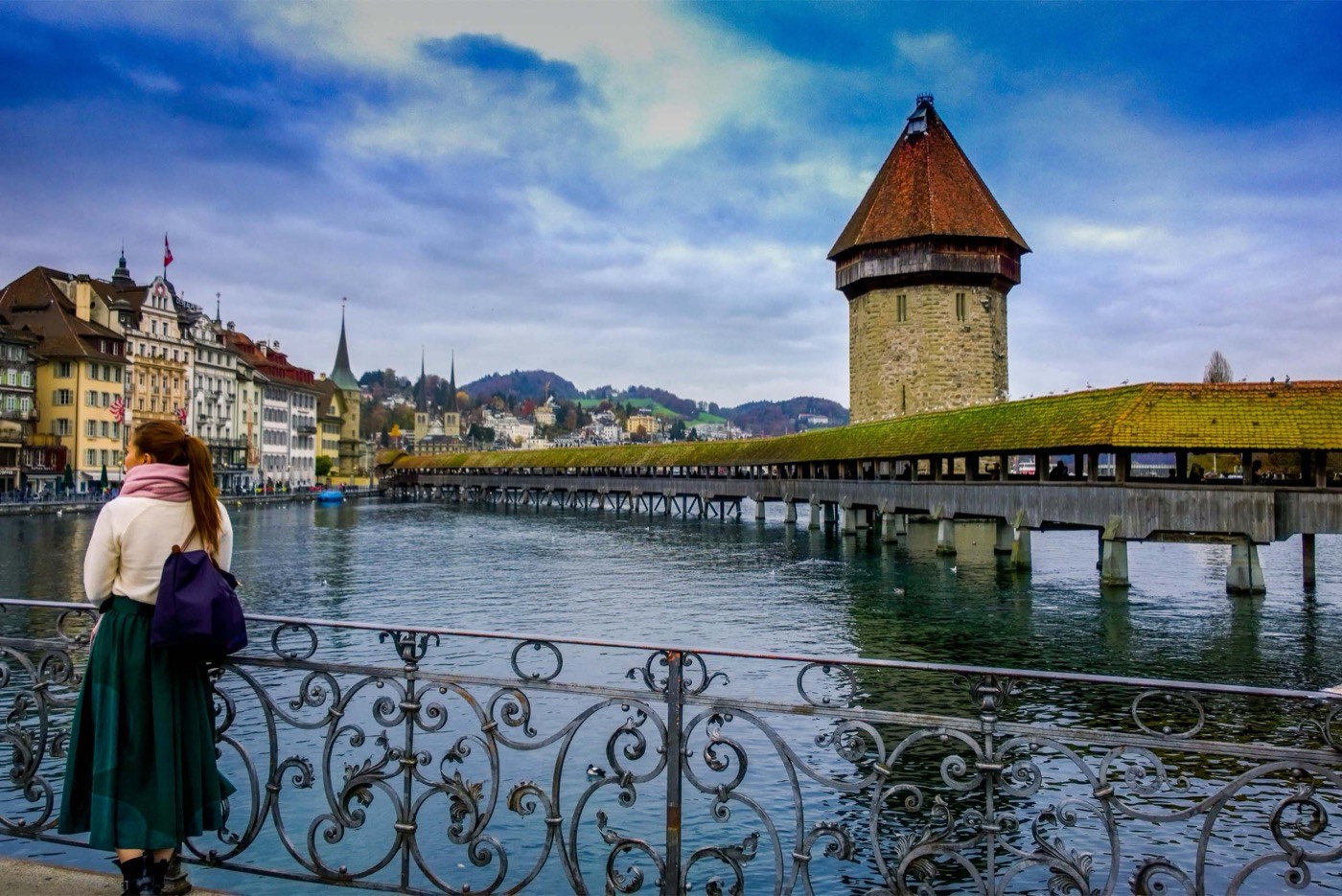 Woman Standing Against Handrails Beside Body Of Water